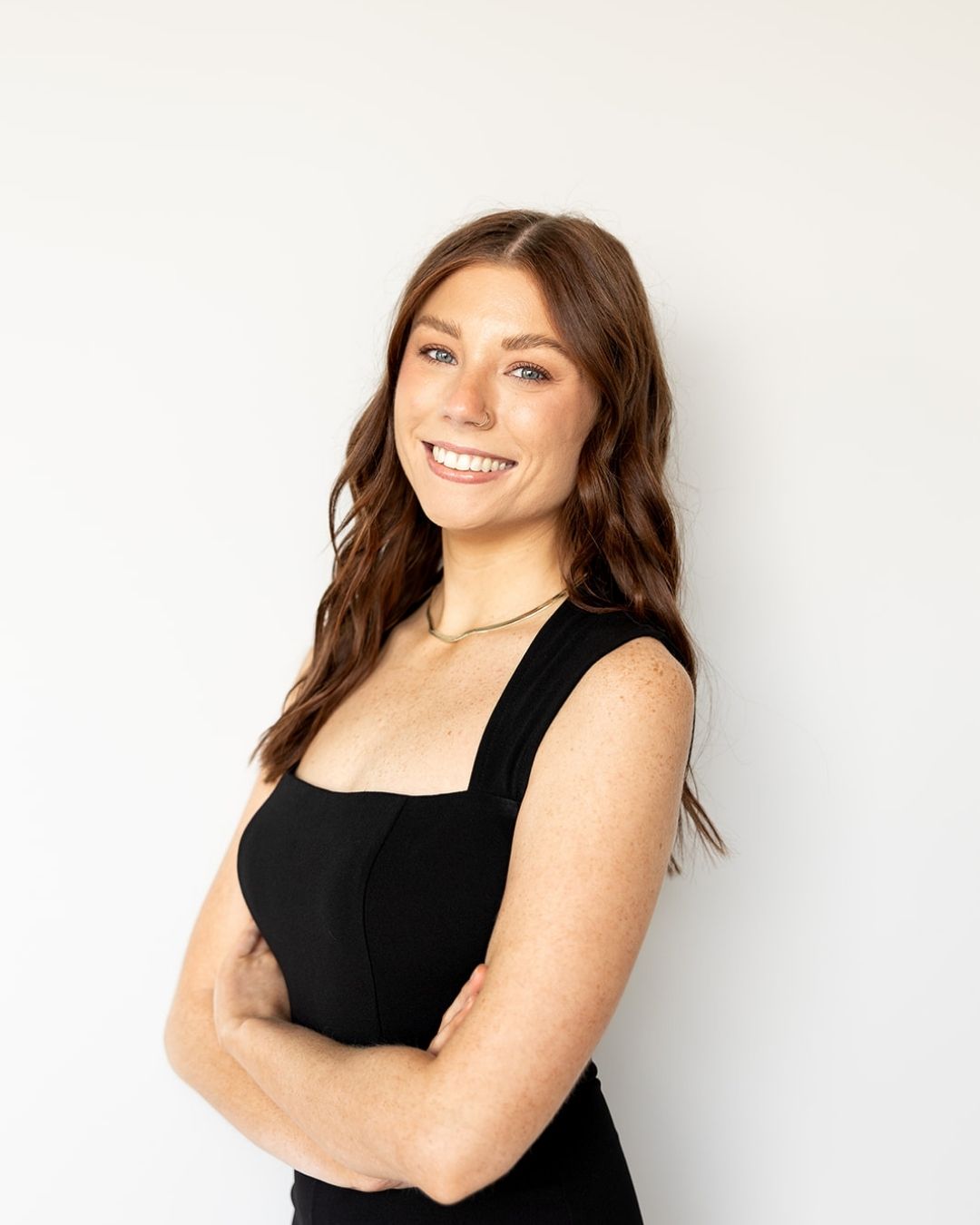 Woman wearing a black sleeveless top against a white background