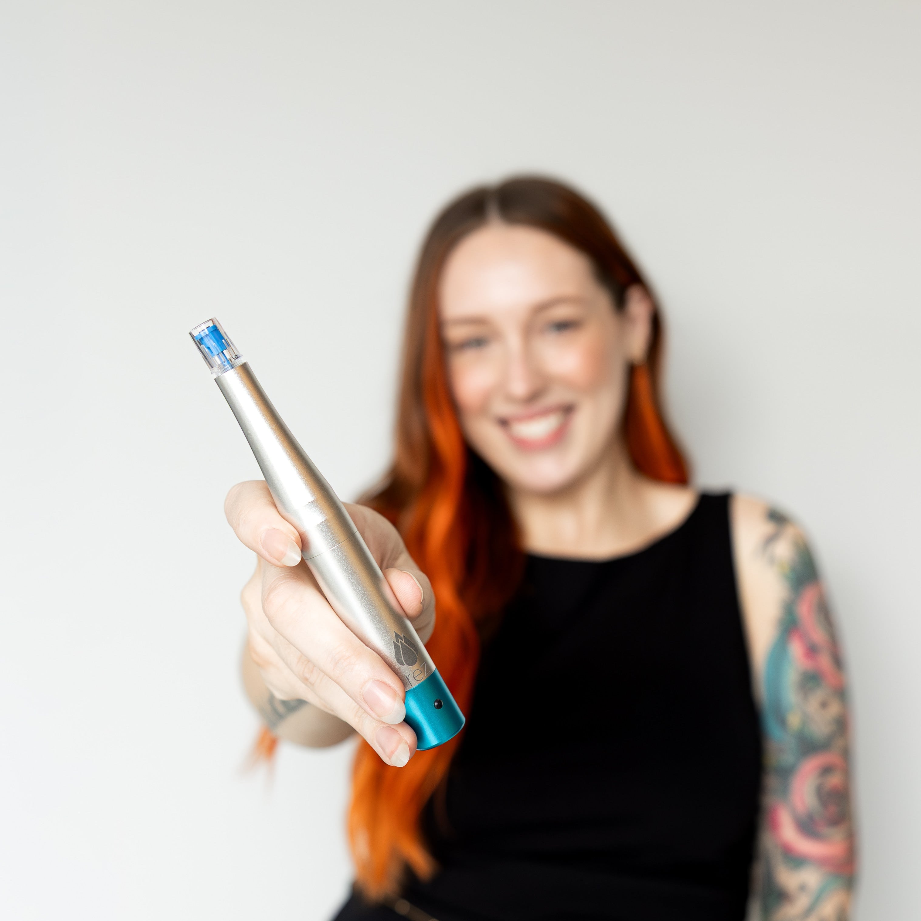 Woman holding a dental tool against a plain background