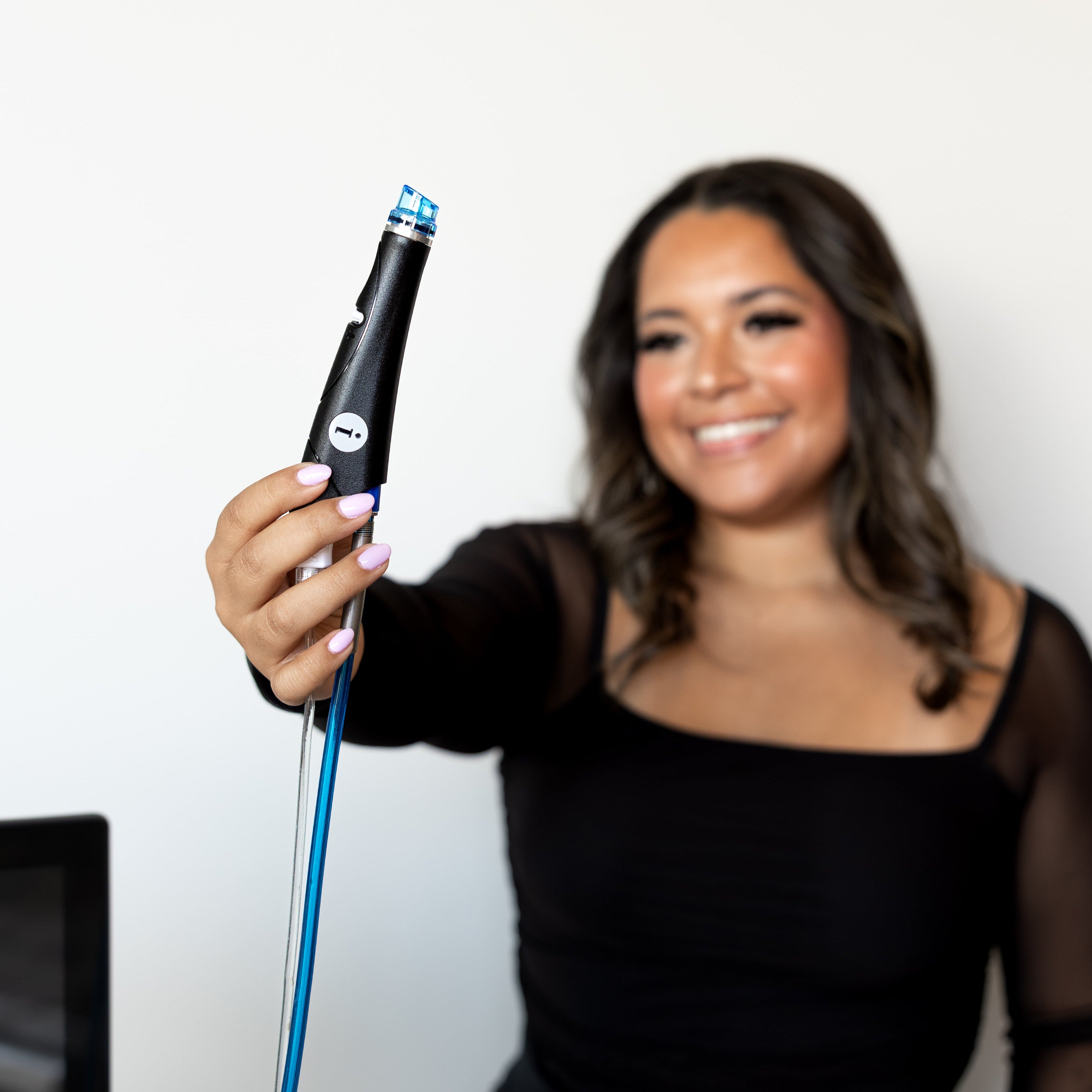 Woman holding a black and blue device against a white background