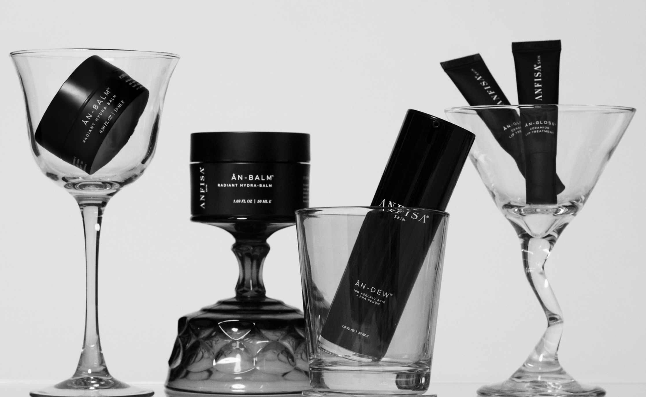 Black skincare products in glass containers on a white background