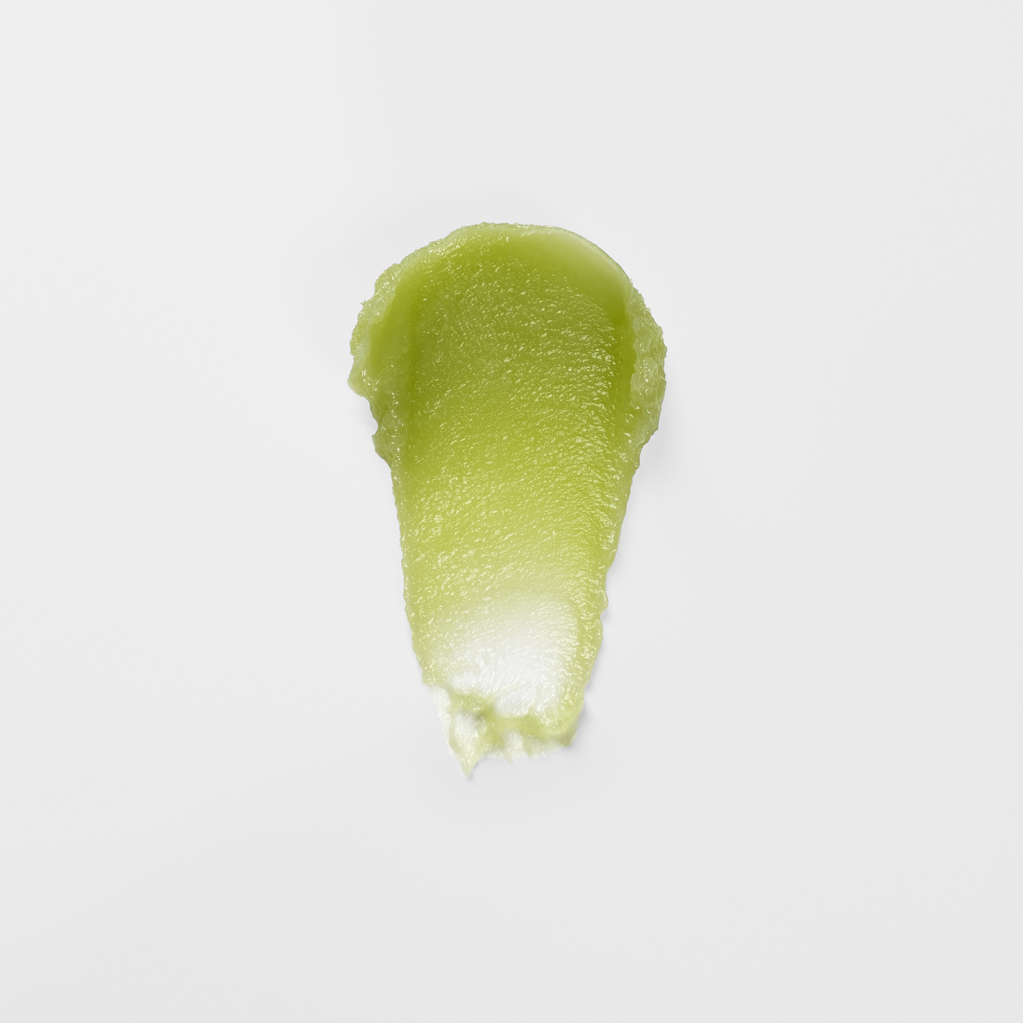 Green lip balm smear on a light gray background