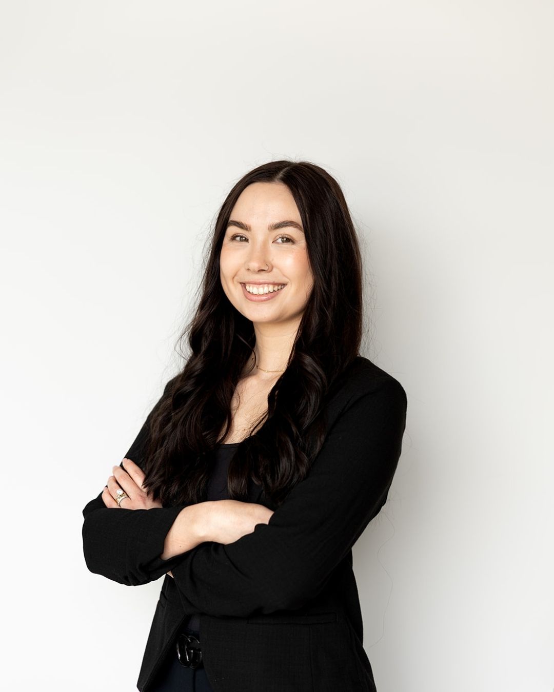 Woman in a black outfit standing against a white background