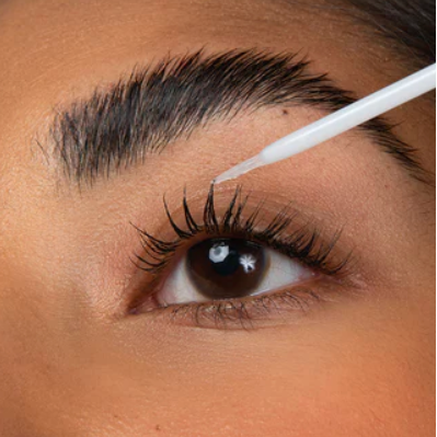 Close-up of a person using a white strip to remove eyelash extensions.